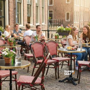 Super-Seat |Red Stapelstühle aus Korbgeflecht und Terrassentische aus Holz draußen an der Kinderstraße. | Catering Möbel