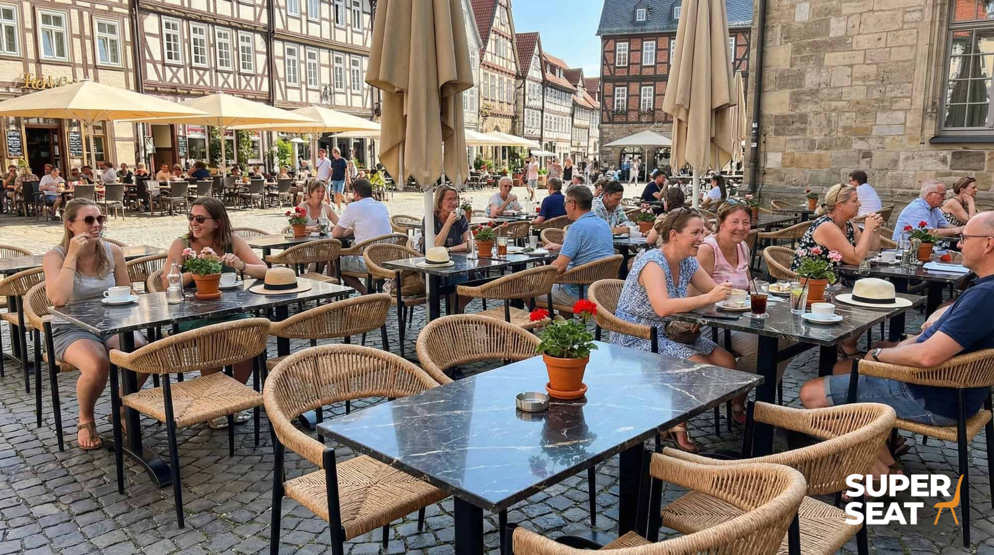 Super-Seat | Gemütliche Terrassenmöbel | Geflochtene Prager Stühle mit Armlehnen, Metalltische, Außenplatz umgeben von alten Gebäuden. | Catering Möbel