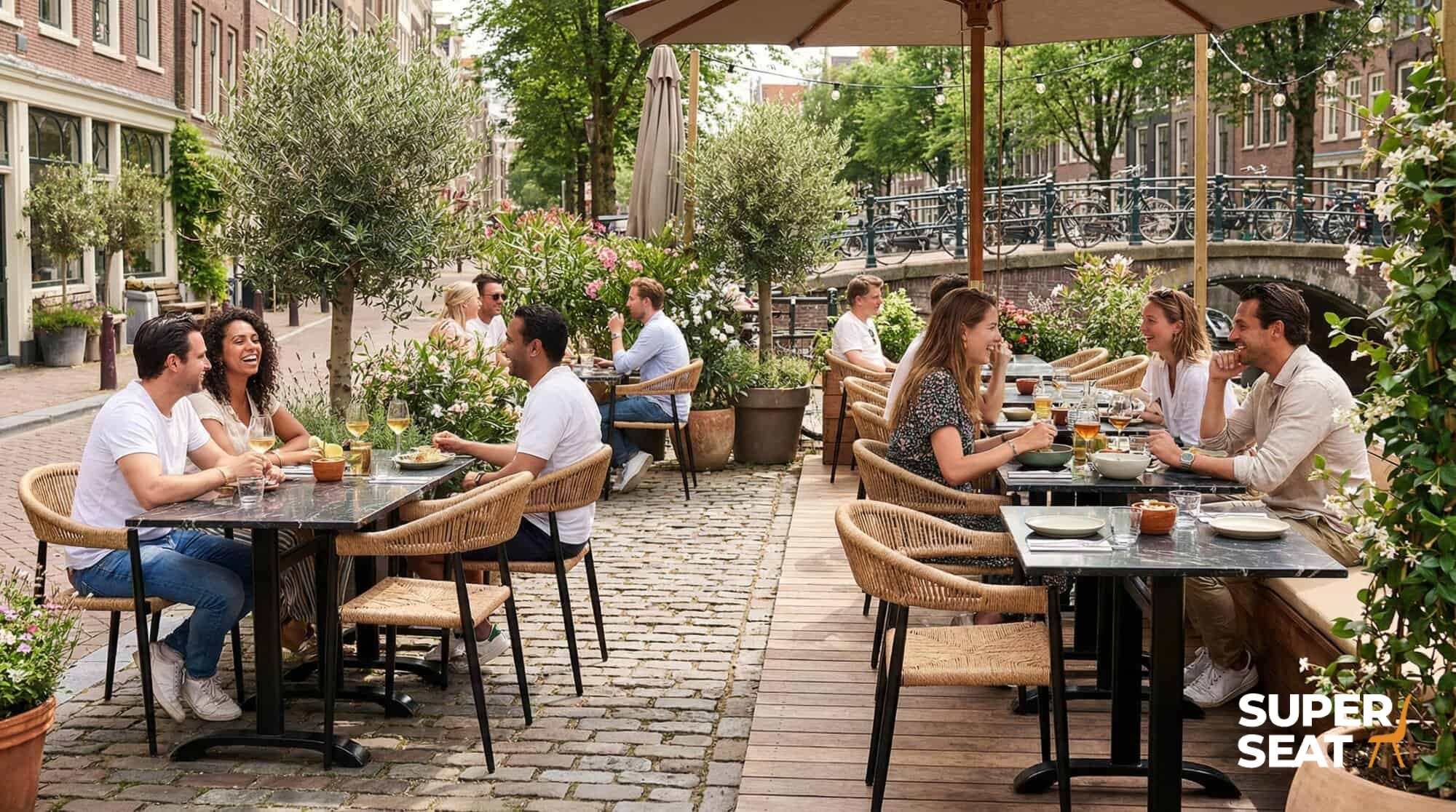 Super-Seat | Prager Terrassenstühle | Geflochtene Kunststoffstühle mit Armlehnen, schwarze Tische; Café im Freien, am Kanal gelegen. | Catering Möbel