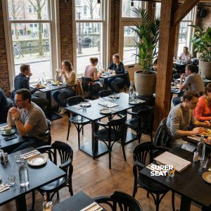 Super-Seat | Thon geschwungene Holz-Café-Sessel Serie schwarz | Schwarze Holzstühle und Tische, Grünpflanzen, Holzboden und Backsteinwände. | Catering Möbel