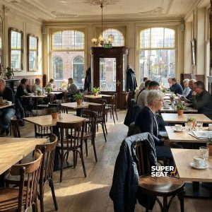 Super-Seat | Café Interieur Holztische, braune gebogene Thon-Stühle mit Bars, Barhocker und viel Sonnenlicht im Raum. | Catering Möbel