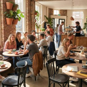 Super-Seat | Café Interieur | Schwarze Thonet-Holzstühle, runde Tische, Backsteinwände, viel Licht und Grün im Café. | Catering Möbel