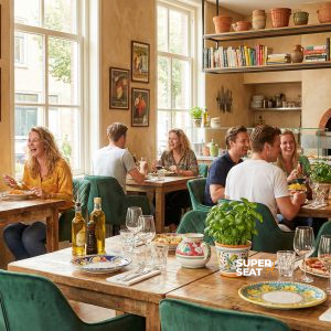 Super-Seat |Houten tafels, groene fluwelen stoelen, zonnig restaurant, pizza en wijn op tafel. | Horecameubilair