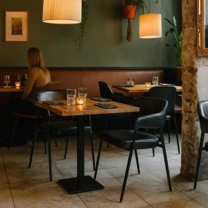 Super-Seat | Ein modernes Restaurantinterieur von Maxwell Hospitality | Donkerhouten tafels, zwarte leren stoelen, metalen lampen, groene planten decoratie. |. | Horecameubilair