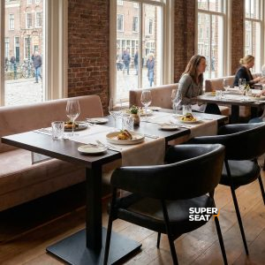 Super-Seat | Schwarze Maxwell-Stühle aus Stoff und Metall, Holztische, Backsteinwand in sonnigem Restaurant. | Catering Möbel