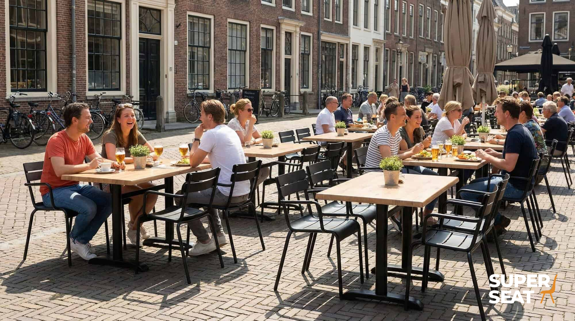 Super-Seat |Holzstühle, kupferfarbene Tische 70x70cm, Rostoptik, Menschen essen draußen auf der Klinkerstraße. | Catering Möbel