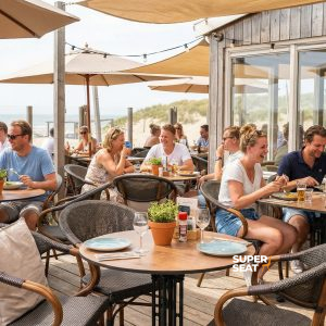 Super-Seat |Holz Teakholz runde Tische 70cm, schwarze Metallstühle, Sonnenschirme, Sanddünen im Hintergrund. | Catering Möbel