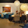 Super-Seat | Ein modernes Wohn- und Esszimmer | Tisch: Holz, gemischte Bestuhlung; Kristallkronleuchter; Blaues Sofa; Dekorative Akzente. | Catering Möbel