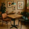 Super-Seat | Ein gemütliches Café mit einem 70x70cm großen Tisch aus Mangoholz der Serie „World“ und zwei nicht zusammenpassenden Stühlen | Tisch aus Mangoholz, eine grüne Stoffbank, Metall- und Holzstühle, warme Beigetöne. | Catering Möbel