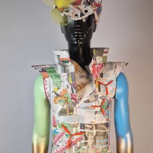 Super-Seat | Schaufensterpuppe mit grellem Outfit aus Zeitungspapier, Tüll und dekorativen Steinen; Arme blau-gold bemalt. | Catering Möbel